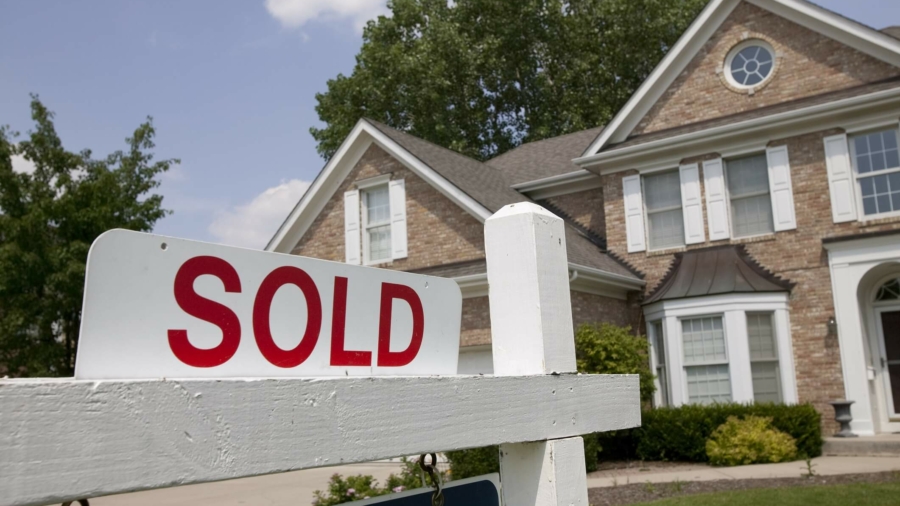 Sold house sign in Midwest suburban setting. Focus on sign.